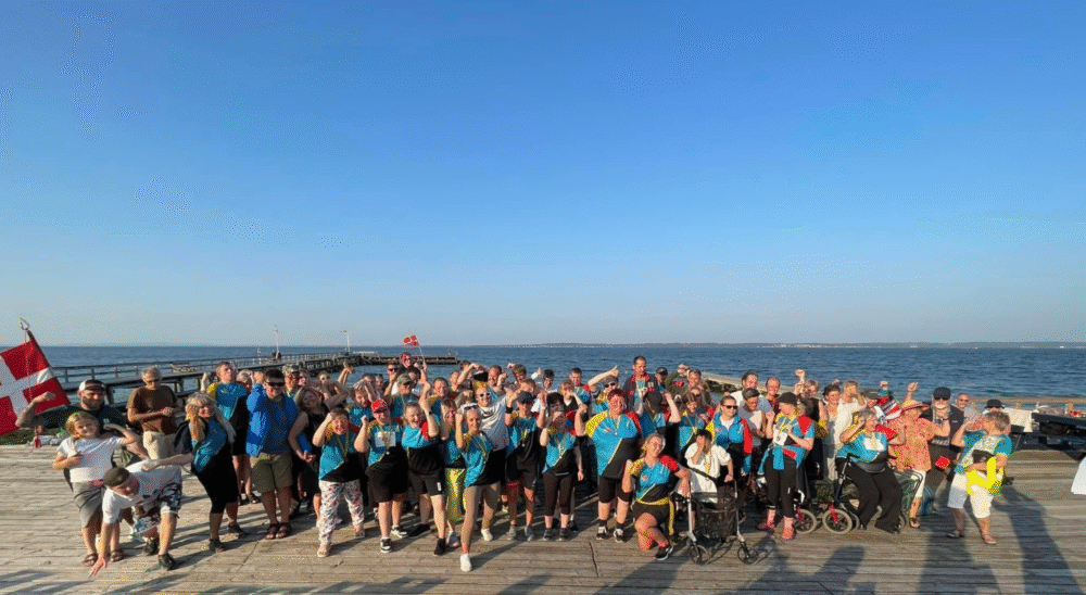Deltagere på Parasport Helsingørs Sommeridrætshøjskole samles på molen til fællesskab og aktivitet ved havet under høj sol.